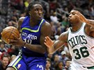 Taurean Prince (vlevo) z Atlanty hledá oima spoluhráe, brání ho Marcus Smart...