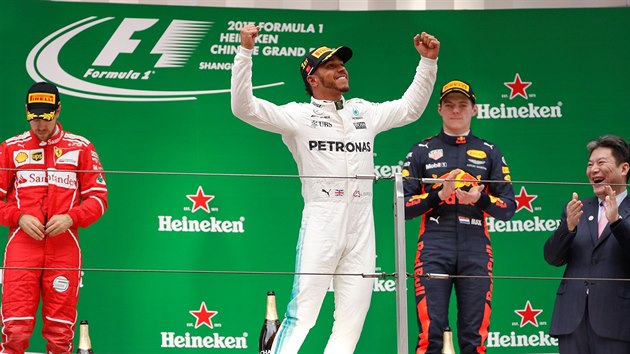 JAKO KING KONG. Lewis Hamilton pzuje po triumfu ve Velk cen ny. Hlavu dole m Sebastian Vettel (vlevo), decentn smv je ve tvi Maxe Verstappena.