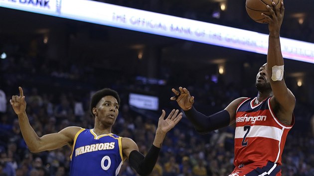 John Wall (vpravo) z Washingtonu zakonuje na ko Golden State, sleduje ho Patrick McCaw.