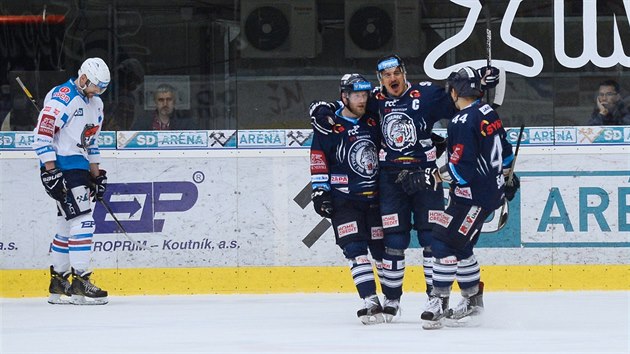 Liberecký kapitán Branko Radivojevič (v modrém uprostřed) slaví se spoluhráči, chomutovský obránce Juraj Valach smutní.