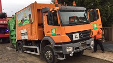 Bhem ranního vyváení odpadu zapadlo popeláské auto v zablácené silnici v...