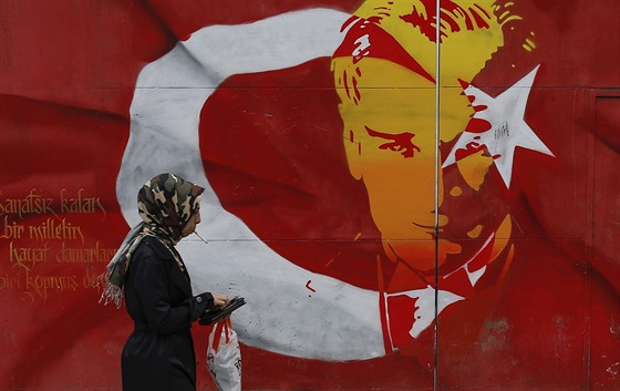 ena prochází kolem plakátu s podobiznou zakladatele Turecké republiky Mustafou...