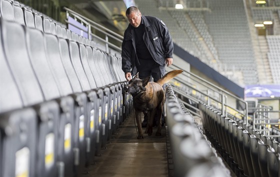 Policista se psem kontrolují tribuny fotbalového stadionu v Dortmundu ped...