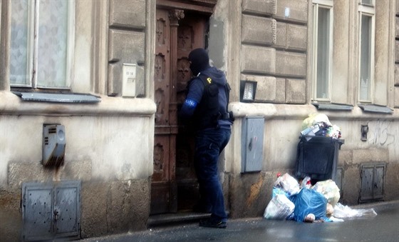 Policista vchází do jednoho z domů v centru Plzně.