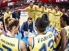 Basketbalistky Fenerbahce Istanbul naslouchají svému trenérovi Firatu Okulovi.