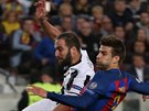Útoník Juventusu Gonzalo Higuaín zakonuje v utkání proti Barcelon, bránit se...