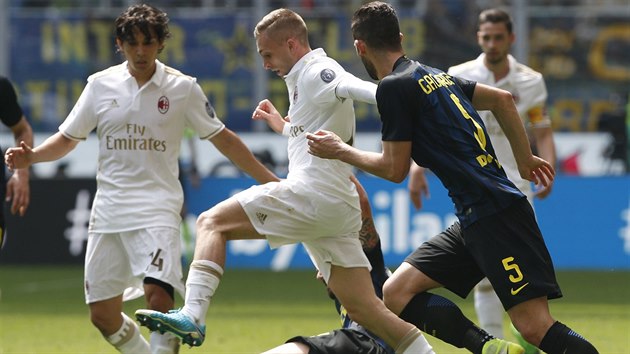 �pan�l Gerard Deulofeu v b�l�m dresu AC Mil�n doluje m�� zpod nohou jednoho z fotbalist� Interu.