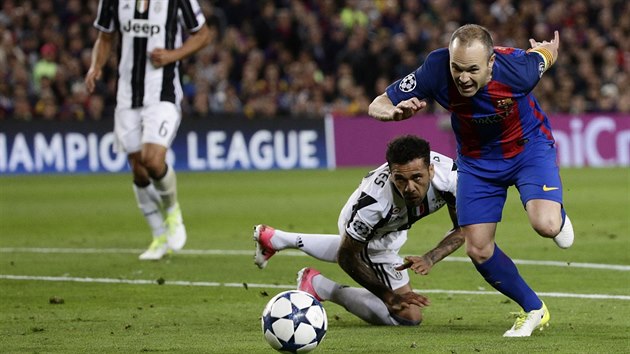 Barcelonsk kapitn Andres Iniesta se dere za balonem, Dani Alves, jeho nkdej spoluhr a nyn soupe z Juventusu, v nefotbalov pozici sleduje.