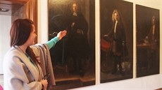 Prvodkyn z mantínského zámku Mirka Topinková ukazuje portréty sluebnictva...