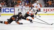 Michael Frolík (vpravo) z Calgary a Ryan Getzlaf z Anaheimu se natahují po puku.