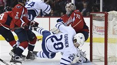 Kasperi Kapanen z Toronta padá ped washingtonským brankáem Bradenem Holtbym.