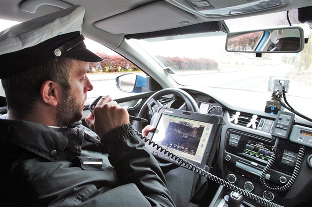 Policista ve vozidle s radarem pi mení rychlosti v sokolovské Tovární ulici.