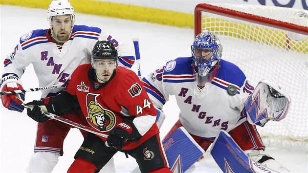 Brank Henrik Lundqvist z New York Rangers, jeho spoluhr Dan Girardi a  Jean-Gabriel Pageau z Ottawy vyhlej, kam polet puk.