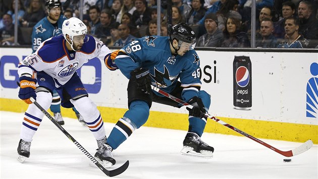 Tom Hertl (vpravo) ze San Jose si hld puk ped Darnellem Nursem z Edmontonu.