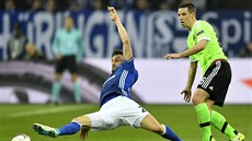 Daniel Caligiuri z Schalke (vlevo) a Nick Viergever z Ajaxu Amsterdam se vrhají...