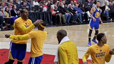 Andre Iguodala (vlevo) slaví se spoluhrái na lavice Golden State trefu...