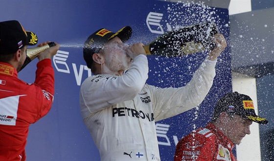 Sebastian Vettel, Valtteri Bottas a Kimi Räikkönen (zleva) slaví na pódiu po...