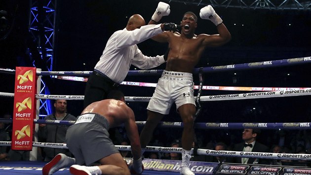 Anthony Joshua slaví titul boxerského mistra světa v těžké váze. U jeho nohou klečí poražený Vladimir Kličko.