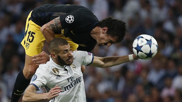 Obrnce Atltika Madrid Stefan Savi v hlavikovm souboji s Karimem Benzemou z Realu.