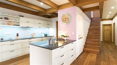 Pastelová kuchyn krásn ladí s výraznými devnými prvky interiéru