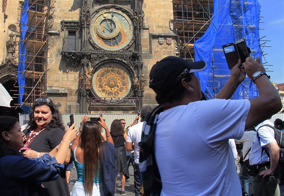 Turisté u rekonstruovaného orloje na Staromstském námstí v Praze