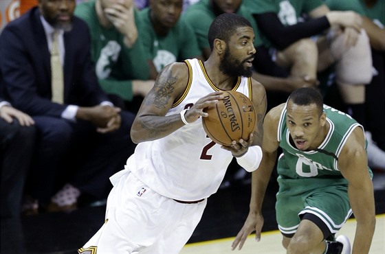 Kyrie Irving z Clevelandu se uvoluje, bránící Avery Bradley z Bostonu klopýtá.