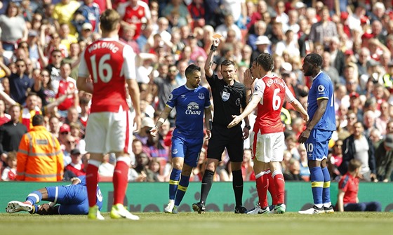 ERVENÁ, JDE VEN. Rozhodí Michael Oliver vyluuje kapitána Arsenalu Laurenta...