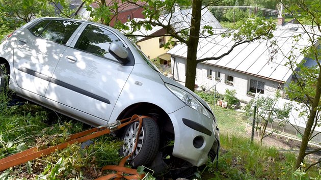 Auto zstalo po nehod viset ze srzu nad rodinnmi domy.