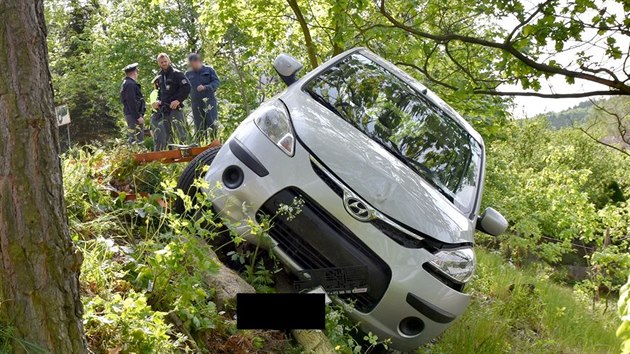 Auto zstalo po nehod viset ze srzu nad rodinnmi domy.