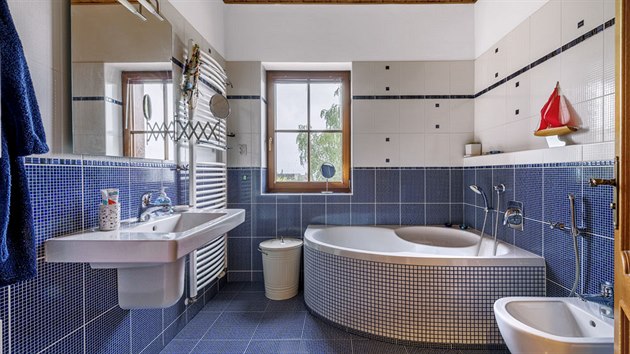 Podkrovn koupelna hrav kombinuje blou a modrou mozaiku na obkladech.