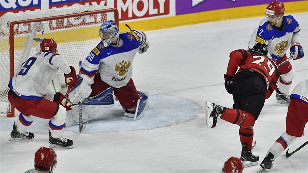 Kanadský útočník Nate Mackinnon (v červenočerném) překonává ruského gólmana Andreje Vasilevského.