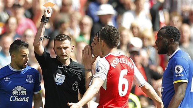 ERVEN, JDE VEN. Rozhod Michael Oliver vyluuje kapitna Arsenalu Laurenta Koscielnho v utkn proti Evertonu.