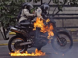 POLICIE V PLAMENECH. Policisté zasaení zápalnou bombou, kterou hodili...