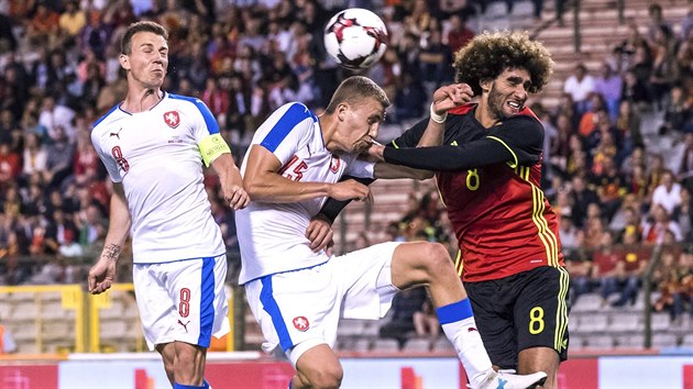 Vladimr Darida (zleva) a Tom Souek v hlavikovm souboji, proti nim belgick ahoun Marouane Fellaini.