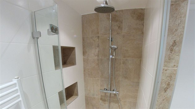 Sprchový kout je bezbariérový, vybavený odtokovým kanálkem v podlaze, hlavovou i ruční sprchou a termostatickou baterií.
