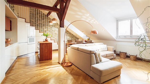 Obývací pokoj s linkou a jídelním koutem osvětlují
vikýřová okna. Místnosti dodávají kouzlo přiznané dřevěné trámy natřené na tmavě hnědý odstín.