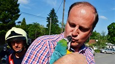 Šťastný majitel se zachráněným papouškem Lórou.