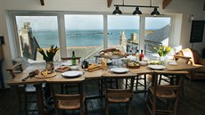 Na kuchyň navazuje jídelní stůl s velkolepým výhledem na moře, na kterém se...