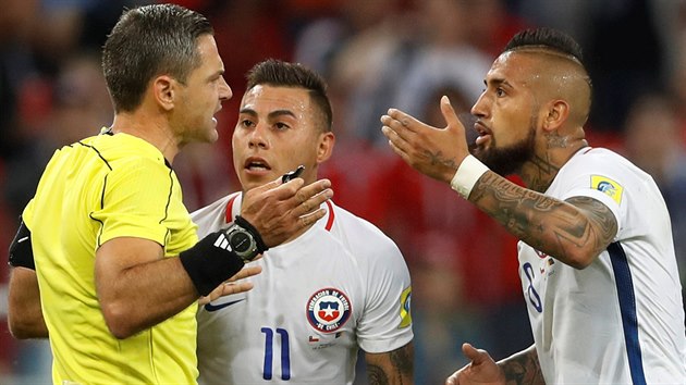 BYL TO OFSAJD, PÁNOVÉ. Rozhodčí Damir Skomina během utkání Chile proti Kamerunu vysvětluje protestujícím Vargasovi s Vidalem, proč neuznal gól.
