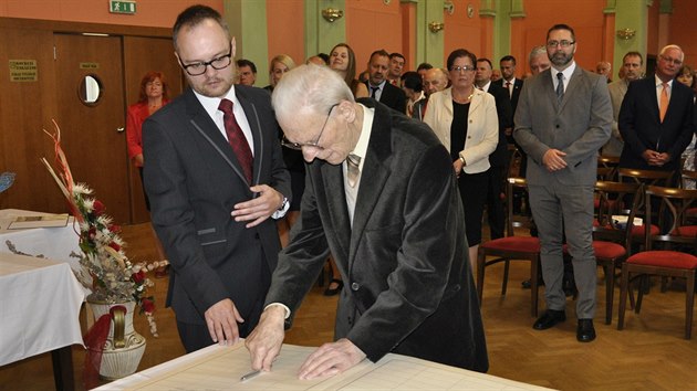 Petr Beck se podepisuje do kroniky města, vlevo starosta Bruntálu Petr Rys. (19. 6. 2017)