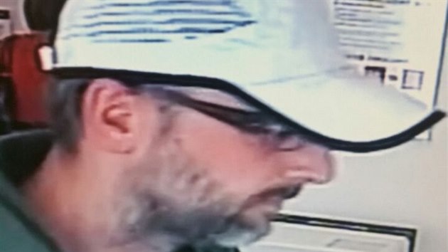 Vousatý muž v kšiltovce, který loupil v kadaňské bance, na snímku z bezpečnostní kamery.