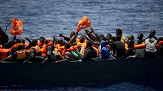 Uprchlíci se snaží chytit záchranné vesty při operaci ve Středozemním moři...