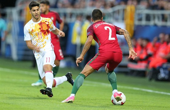 panlská hvzda Marco Asensio (vlevo) v souboji s portugalským bekem Joaoem...