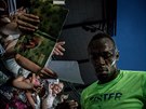 Usain Bolt se podepisuje fanoukm na Zlaté trete.