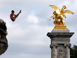A diver performs from the Pont Alexandre III bridge into the River Seine in...