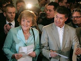 Angela Merkelová (CDU/CSU) s manelem Joachimem Sauerem odevzdávají v Berlín...