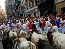 Runners sprint ahead of bulls during the first running of the bulls at the San...