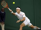 Japonec Kei Niikori se natahuje po míku v zápase prvního kola Wimbledonu...