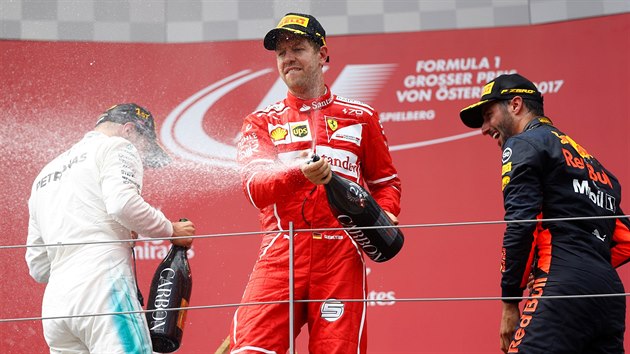 Nejlep zvodnci Velk ceny Rakouska slav. Vrchnm ostikovaem je Sebastian Vettel (druh msto), vlevo se kr vtzn Valterri Bottas, vpravo se checht tet Daniel Ricciardo.