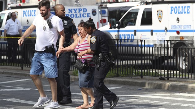 Policist pomhaj lidem opoutjcm nemocnici v New Yorku, kde toil bval zamstnanec (30.6.2017).